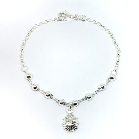 Pulsera con bolitas y dije de vaquita de San Antonio